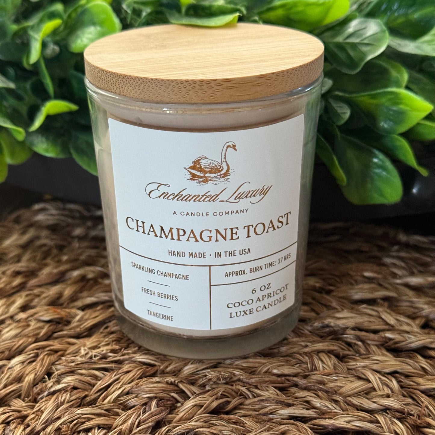a jar of champagne toast sits on a table next to a potted plant